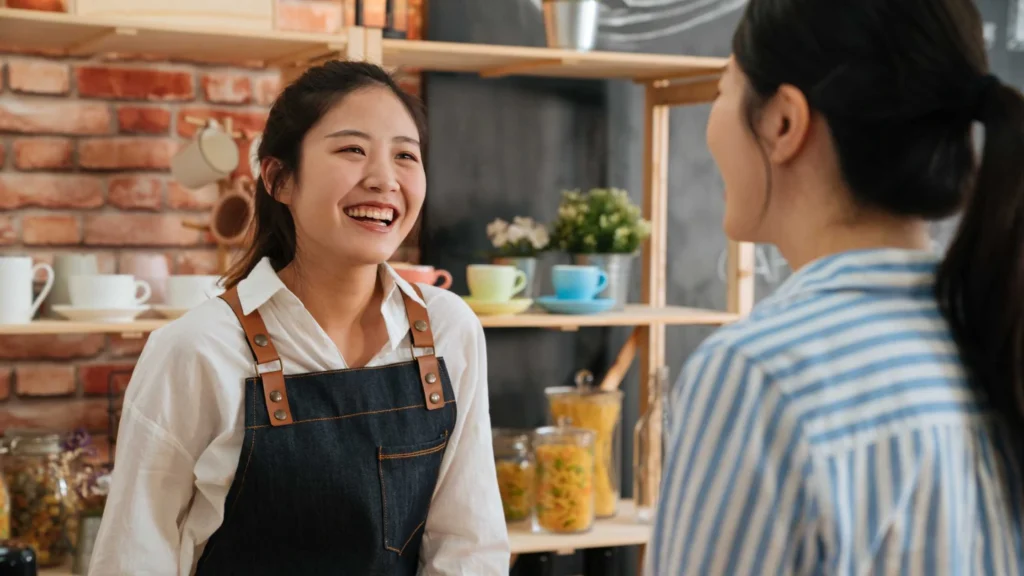 Visual pelaku UMKM tersenyum berbicara dengan pelanggan.